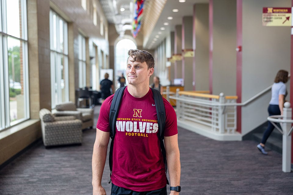 Student walking inside campus building